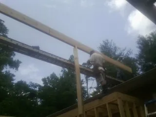Carpenter setting a ridge beam over a new addition frame — Ice Dam Removal by Roofing Brothers in Maggie Valley