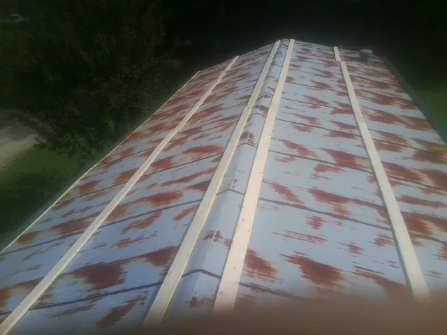 Rusted metal roof panels with new wood purlins before replacement — Storm Damage Roof Repair in Maggie Valley by Roofing Brothers