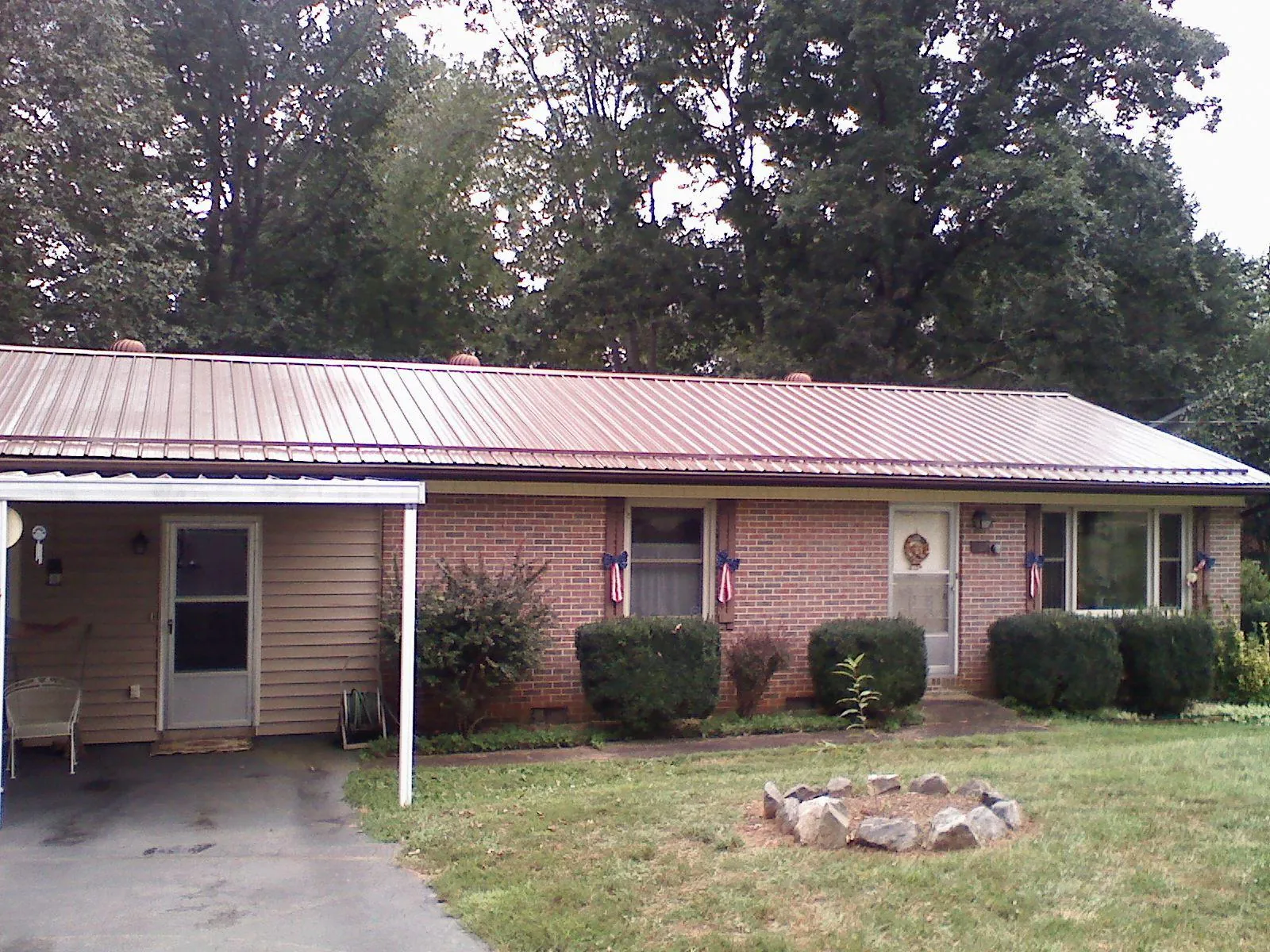 Bronze metal roof and carport on a brick ranch home — Roof Repair work by our crew in Maggie Valley