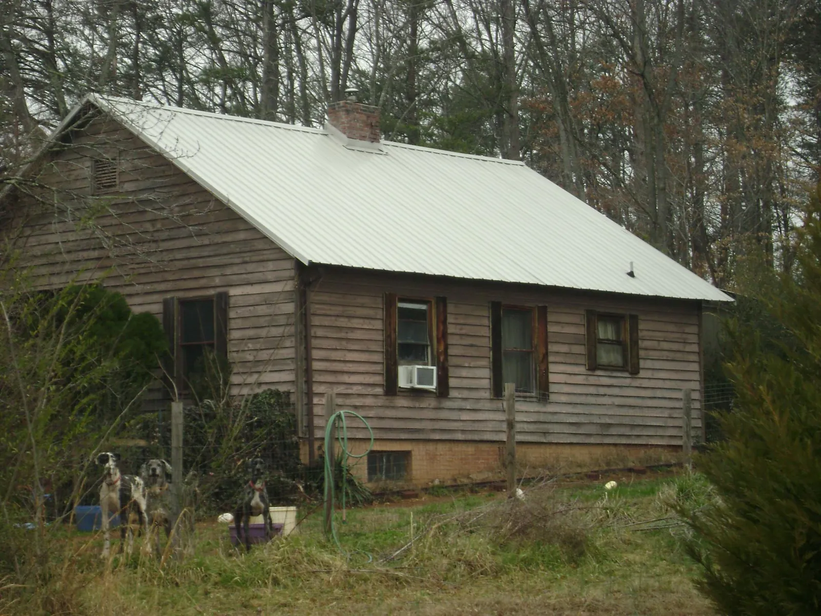 White metal roof on an old wood sided farmhouse, from a Metal Roof Installation job in Maggie Valley